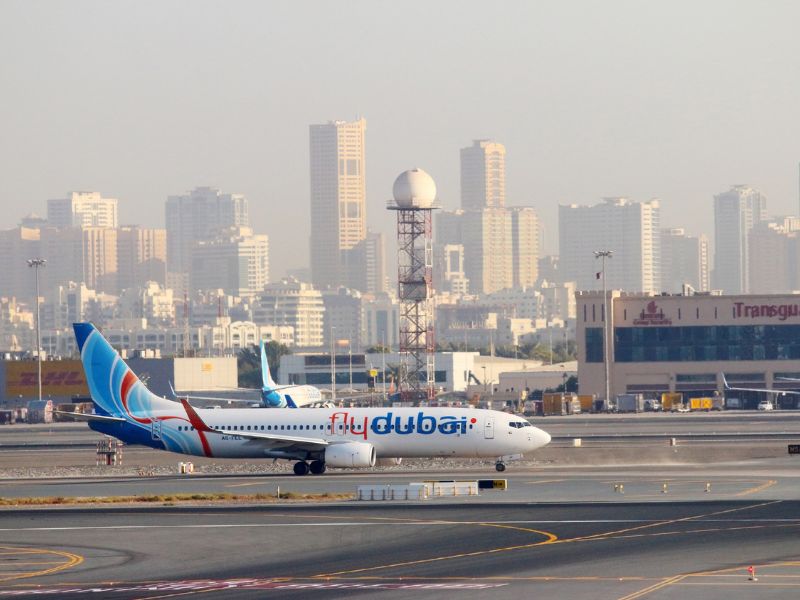 Airport Flughafen von Dubai mit Flugzeug und Skyline im Hintergrund
