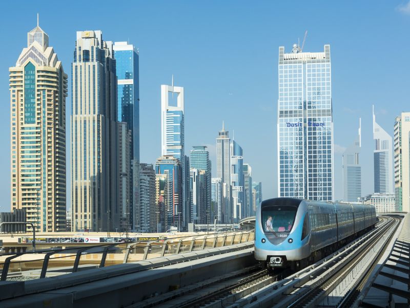 Die Dubai Metro vor der Skyline der Stadt