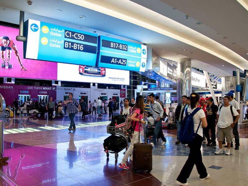 Passagiere mit Gepäck unterwegs in Dubai am Airport